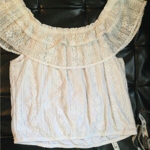 Blouse white and features ruffles at the neckline.